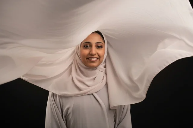 Smiling Arab Woman in Flying Hijab on Black Background