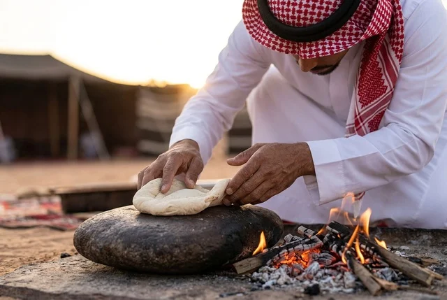 رجل سعودي يخبز الخبز التقليدي على النار