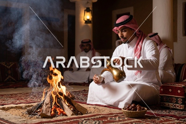 رجل سعودي يصب القهوة العربية بجانب شبة النار في المجلس