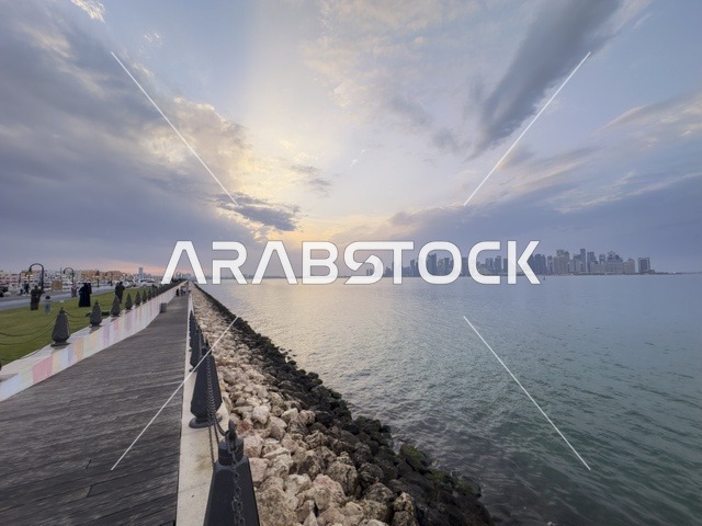 ممشى كورنيش الدوحة مع أفق الخليج الغربي وقت الغروب