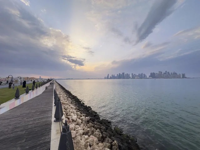 ممشى كورنيش الدوحة مع أفق الخليج الغربي وقت الغروب