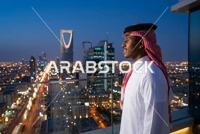 رجل سعودي يرتدي الزي التقليدي يطل على أفق الرياض ليلاً