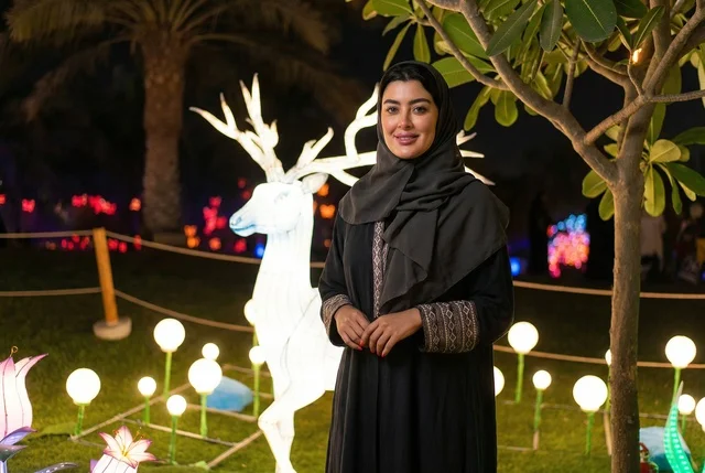 امرأة إماراتية في مهرجان الأضواء بالحديقة ليلا