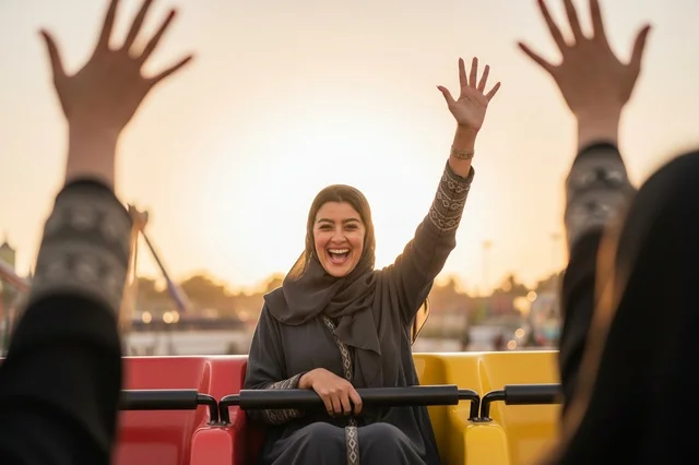 امرأة سعودية سعيدة في مدينة الملاهي الترفيهية وقت الغروب