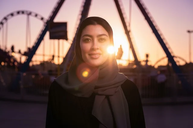 Saudi Woman Wearing Hijab at Theme Park at Sunset
