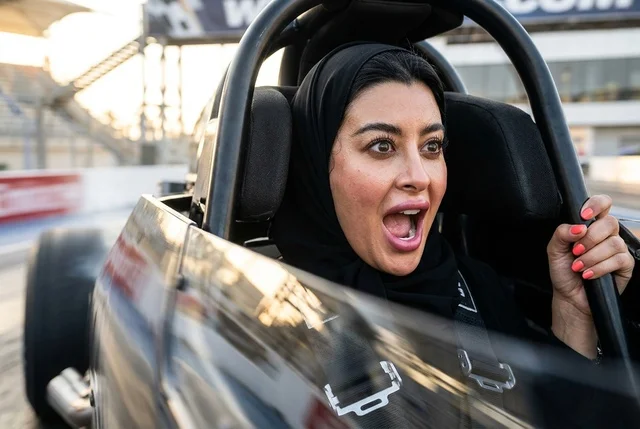 Excited Saudi Woman Driving Racing Car on Racetrack