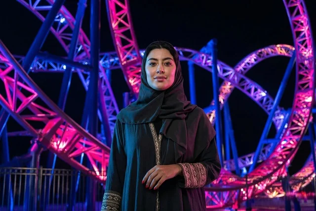 امرأة سعودية في مدينة الملاهي الترفيهية ليلا