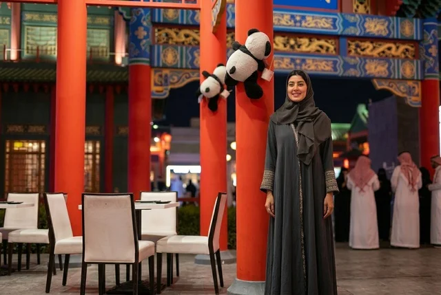 امرأة عربية بالعباءة في المنطقة الصينية خلال الليل