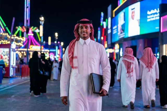 مواطن سعودي بالزي التقليدي في بوليفارد الرياض ليلاً