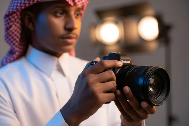 مصور سعودي يحمل كاميرا احترافية داخل استوديو تصوير