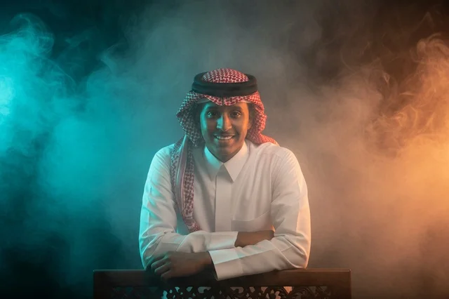 بورتريه رجل سعودي بالزي التقليدي مع خلفية دخان ملون