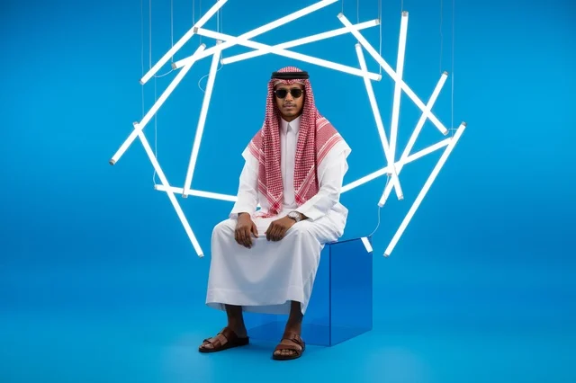 رجل سعودي بالثوب التقليدي مع إضاءة نيون بالاستوديو