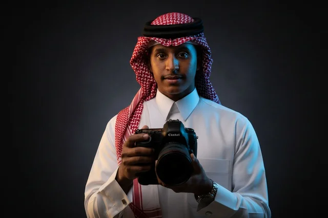 مصور سعودي بالثوب التقليدي يمسك كاميرا احترافية