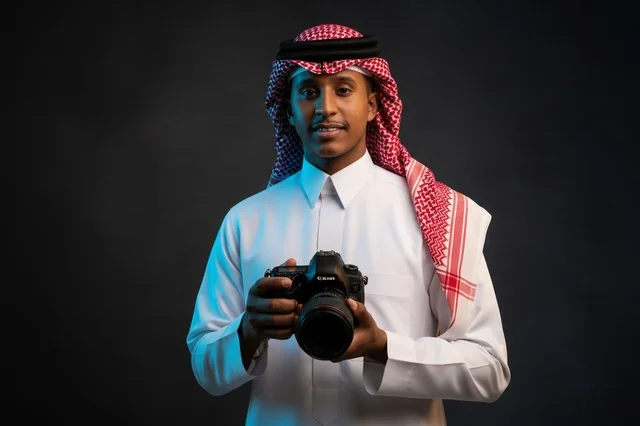 مصور سعودي بالزي التقليدي يحمل كاميرا احترافية