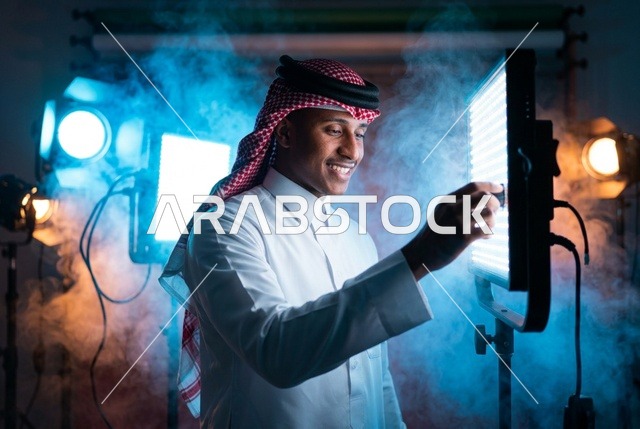 شاب سعودي يضبط لوحة إضاءة الاستوديو الاحترافية