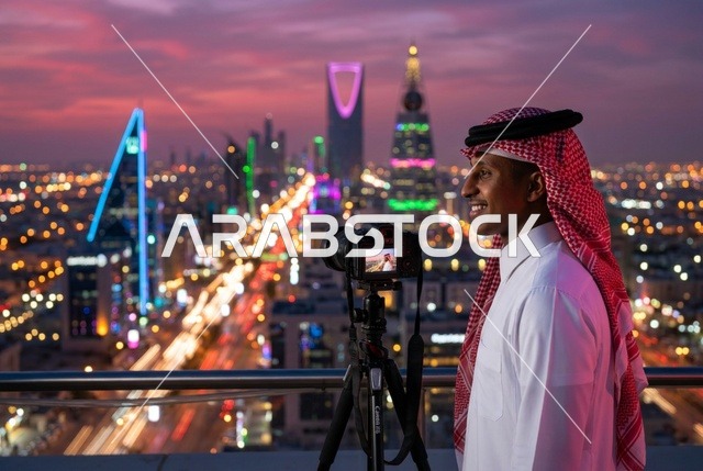 مصور سعودي مع كاميرا يطل على أفق مدينة الرياض ليلا