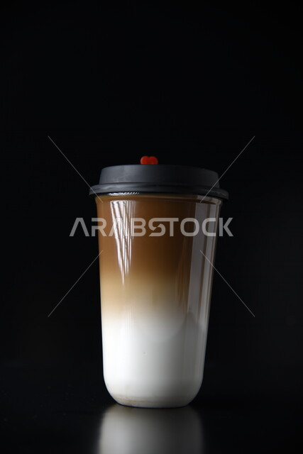 صورة مقربة لكأس بلاستيكي من القهوة الساخنة اللذيذة مصورة على خلفية سوداء ، مشروبات ساخنة لذيذة ، مشروب كابتشينو ، قهوة الشوكولاته الساخنة