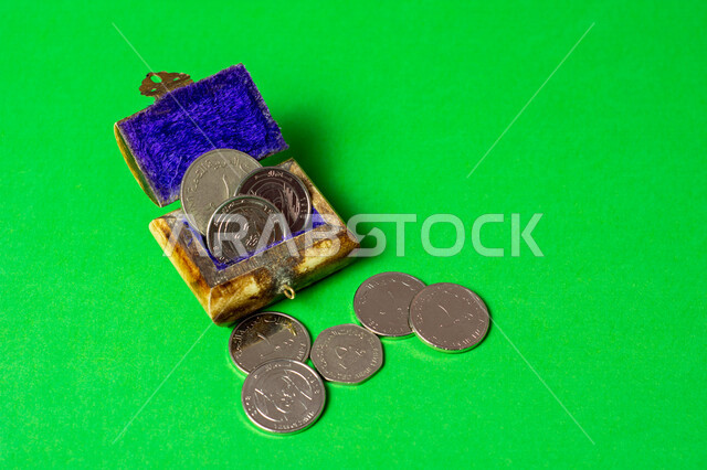 مجموعة من العملات النقدية من فئة الدرهم داخل صندوق أثري قديم ، صندوق المال ، حصالة نقود قديمة مصورة على خفية خضراء ، الكروما الخضراء