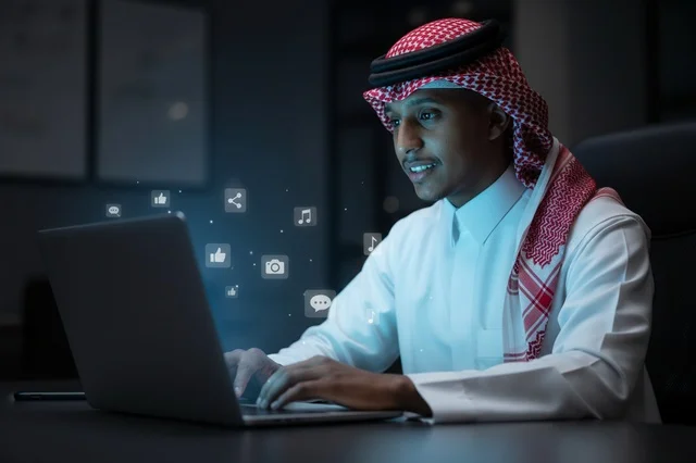 رجل سعودي يعمل على الكمبيوتر المحمول مع أيقونات رقمية