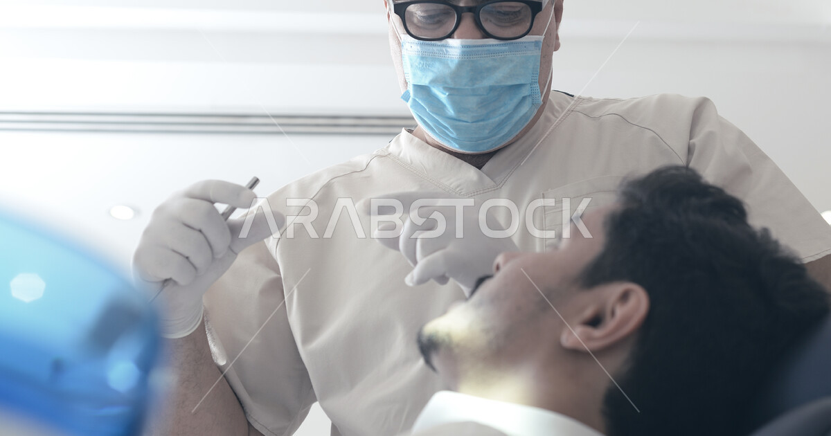A Saudi Arabian Gulf dentist wearing gloves and a medical mask