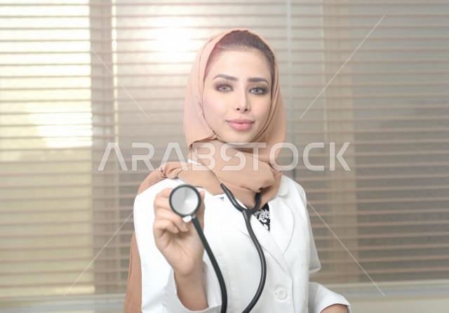 طبيبة عربية خليجية سعودية ترتدي المعطف الطبي وتحمل بيها السماعة الطبية ، ايماءات وجه ويدين مختلفة ، العمل في القطاع الصحي ، تقديم الاستشارات الطبية والخدمات الصحية، مفهوم الطب والرعاية الصحية