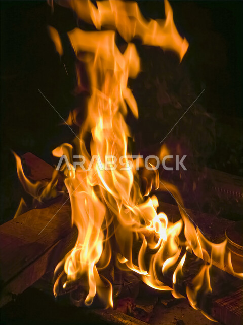 صورة مقربة لنيران مشتعلة بالحطب ، رحلات برية ، جلسة بر عربية في صحراء السعودية ، شبة نار ، الشرارات الساخنة المحترقة ، البر و التخييم ، صورة للنار المتوهجة 