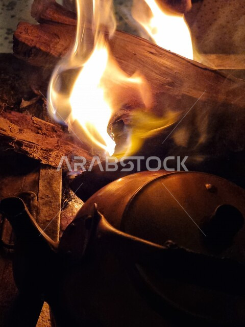 صورة مقربة لإعداد الشاي على حطب النار المشتعلة ، حطب مشتعل بالنيران ، رحلات برية ، جلسة بر عربية في صحراء السعودية ، شبة نار ، الشرارات الساخنة المحترقة ، صورة للنار المتوهجة ، أجواء شتوية ، إبريق الشاي على النار