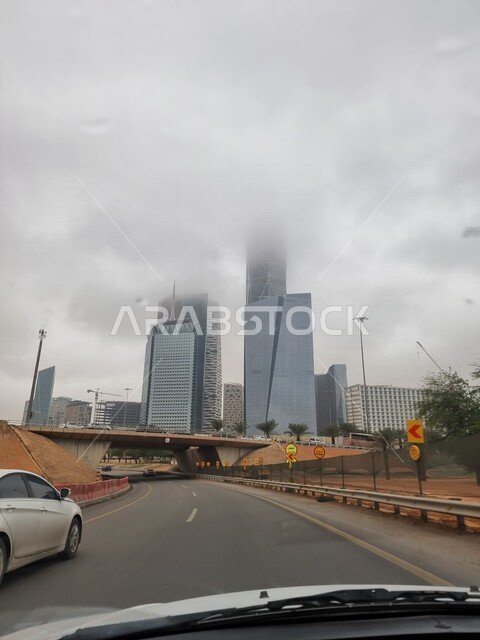 صورة لمركز الملك عبدالله المالي ( كافد ) في الرياض بالمملكة العربية السعودية ، أجواء ضبابية ، أبراج وناطحات السحاب مغطية بالغيوم ، السياحة في السعودية ، المعالم السياحية المشهورة في الرياض ، الفن الهندسي المعماري بالسعودية 