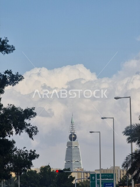 صورة جمالية لبرج الفيصلية مغطى بسحابة بيضاء في مدينة الرياض بالمملكة العربية السعودية ، أبراج مدينة الرياض ، معالم مشهورة في الرياض ، الفن الهندسي المعماري في السعودية ، السياحة في السعودية ، برج الفيصلية