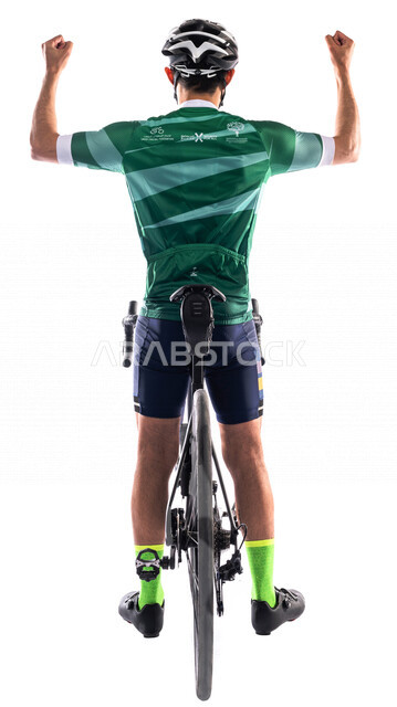 بورتريه من الخلف لرجل عربي خليحي سعودي يرتدي الملابس الرياضية وخوذة الحماية، ركوب دراجة السباق الهوائية، نشاط بدني، المحافظة على اللياقة الجسدية، حركة يدين تدل على الحماس بالفوز، خلفية بيضاء، صورة الجسم بالطول الكامل