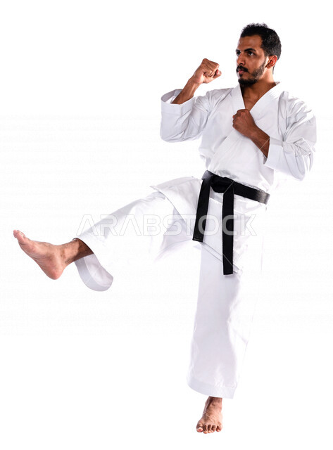 Portrait of a Saudi Arabian Gulf man practicing Japanese karate, white karate uniform with black belt, training in special combat movements, Japanese martial arts, martial arts, physical strength, application of kata movements, white background, full-leng