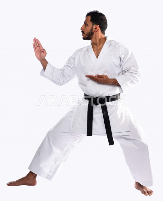 Portrait of a Saudi Arabian Gulf man practicing Japanese karate, white karate uniform with black belt, training in special combat movements, Japanese martial arts, martial arts, physical strength, application of kata movements, white background, full-leng