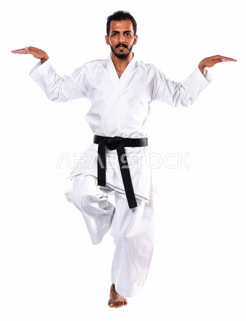Portrait of a Saudi Arabian Gulf man practicing Japanese karate, white karate uniform with black belt, training in special combat movements, Japanese martial arts, martial arts, physical strength, application of kata movements, white background, full-leng