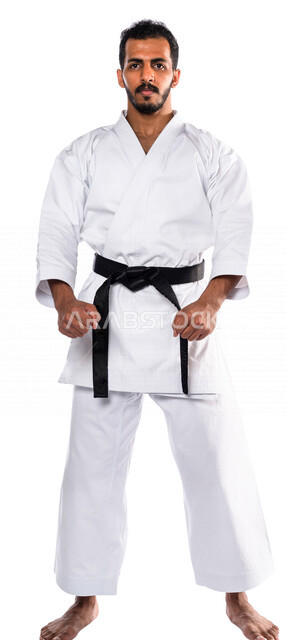 Portrait of a Saudi Arabian Gulf man practicing Japanese karate, white karate uniform with black belt, training in special combat movements, Japanese martial arts, martial arts, physical strength, application of kata movements, white background, full-leng