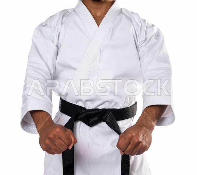 Portrait of a Saudi Arabian Gulf man practicing Japanese karate, white karate uniform with black belt, training in special combat movements, Japanese martial arts, martial arts, physical strength, kata movements, white background