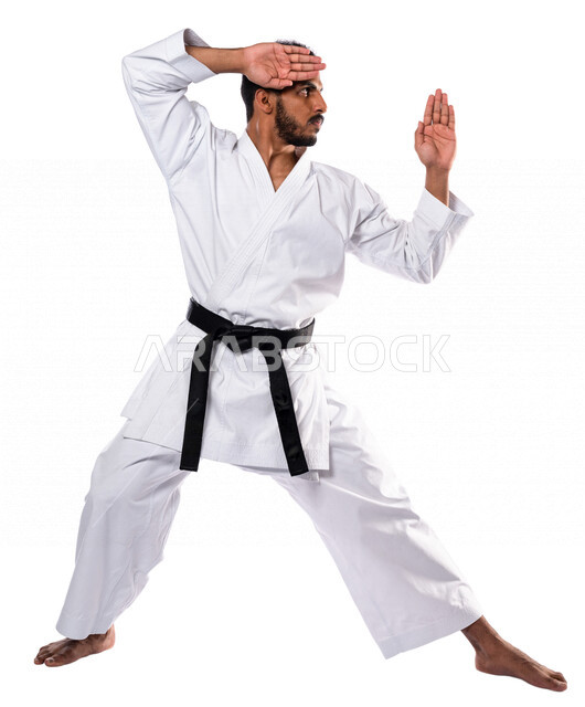 Portrait of a Saudi Arabian Gulf man practicing Japanese karate, white karate uniform with black belt, training in special combat movements, Japanese martial arts, martial arts, physical strength, application of kata movements, white background, full-leng