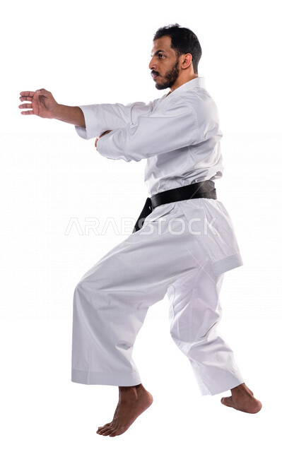 Portrait of a Saudi Arabian Gulf man practicing Japanese karate, white karate uniform with black belt, training in special combat movements, Japanese martial arts, martial arts, physical strength, application of kata movements, white background, full-leng