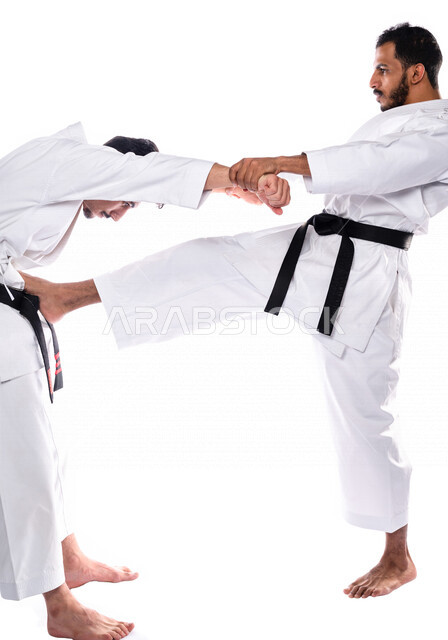 Portrait of a Saudi Arabian Gulf man training his student in the movements of karate, white karate uniform with black belt, training in special combat movements, Japanese martial arts, martial arts, application of kata movements, white background, full-le