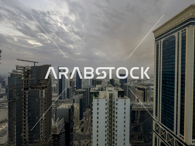  Elevated panoramic view of Doha city with modern skyscrapers in West Bay district and a main road leading towards Doha Corniche and the Arabian Gulf under a partly cloudy sky, Doha, Qatar