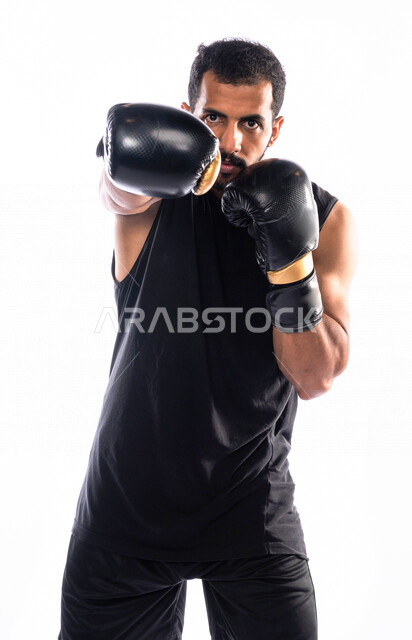 Portrait of a Saudi Arabian Gulf man wearing boxing gloves, practicing self-defense, discharging negative energy, training in combat movements, boxing and wrestling, health and fitness, the Saudi national boxing team