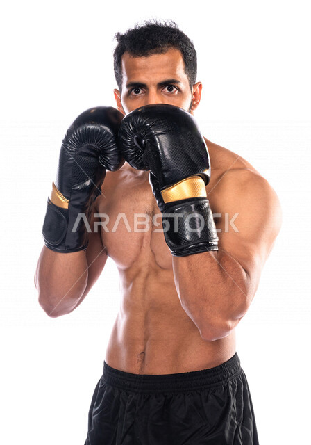 Portrait of a Saudi Arabian Gulf man wearing boxing gloves, practicing self-defense, discharging negative energy, training in combat movements, boxing and wrestling, health and fitness, the Saudi national boxing team