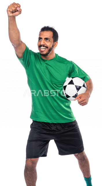 بورتريه لرجل عربي خليجي سعودي يرتدي لباس فريق لعبة كرة القدم ويحمل بيده الكرة ، ايماءات الوجه واليدين تدل على الفوز ، لاعب كرة قدم محترف ، ممارسة تمرينات رياضة كرة القدم،  تسجيل الاهداف ، هواية اللعب بالكرة  ، المنتخب الوطني السعودي لكرة القدم