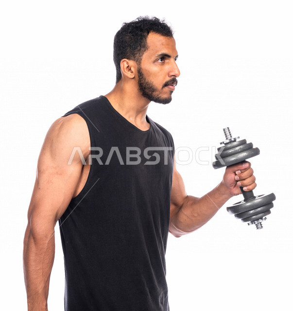 بورتريه لشاب عربي خليجي سعودي يقوم بممارسة التمارين الرياضية مع الدمبل ، نشاط بدني للمحافظة على الصحة و اللياقة الجسدية ، تقوية عضلات الجسم و بنائها ، تمارين رفع الأثقال (دمبلز)، رفع الأوزان الحديدية الثقيلة ، كمال الأجسام ، لياقة و رشاقة