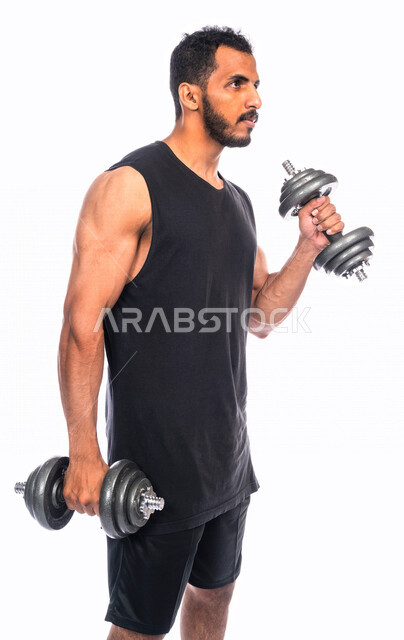 Portrait of a Saudi Arabian Gulf youth doing aerobic exercise with dumbbells, physical activity to maintain health and physical fitness, strengthening and building body muscles, weight lifting exercises (dumbbells), lifting heavy iron weights, bodybuildin