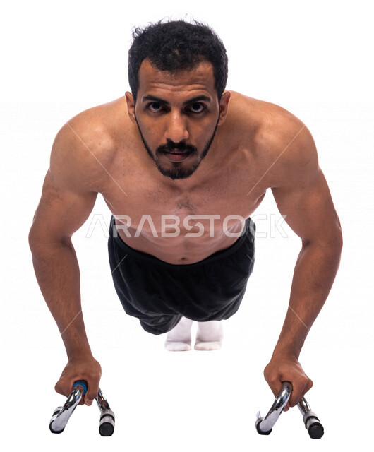 بورتريه لشاب عربي خليجي سعودي يقوم بممارسة تمارين الضغط الرياضية بواسطة أداة تمارين الضغط بوش أب استانلس يد فوم ، نشاط بدني للمحافظة على الصحة و اللياقة الجسدية ، تقوية عضلات الصدر و الجسم ، أدوات و معدات رياضية ، أسلوب حياة صحي ، لياقة و رشاقة