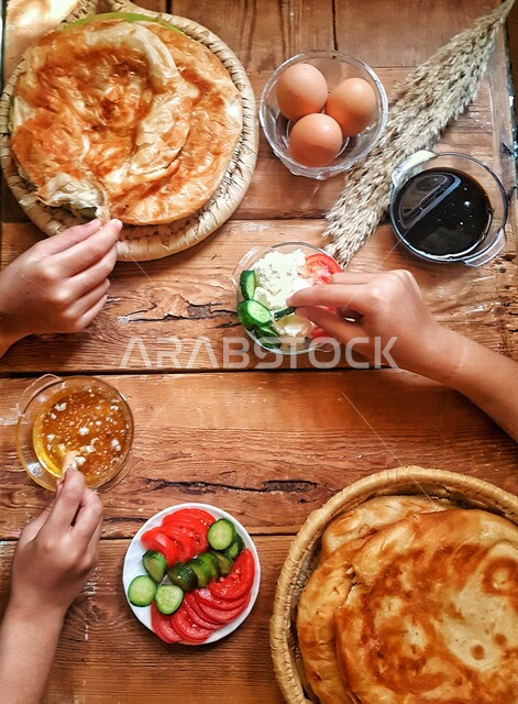 صورة مقربة من أعلى لأيدي مجموعة أشخاص يتناولون وجبة الفطور ، وجبات عربية ، وصفات وأطباق طعام لذيذة ، مأكولات صحية