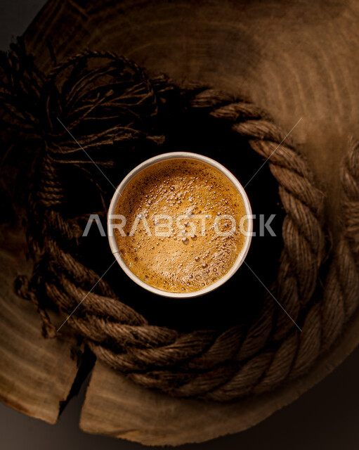 A picture from above of a coffee cup on a wooden surface, a delicious cup of coffee, delicious warm drinks, preparing and preparing a coffee drink, espresso coffee