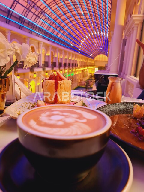 صورة لفنجان القهوة واطباق الحلويات الباردة في احد مطاعم وكافيهات السعودية ، مشروب اللاتيه الساخن ، الكابتشينو اللذيذ ، جلسة هادئة ، مقاهي المملكة العربية السعودية