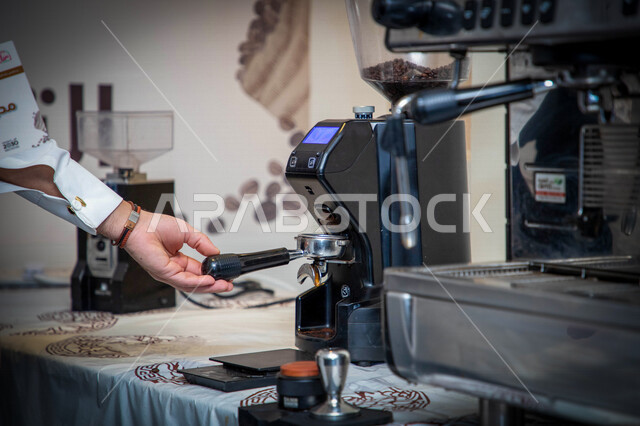 Close-up of a man's hand using a coffee maker, a coffee maker, making and brewing fresh coffee, making hot drinks from coffee beans