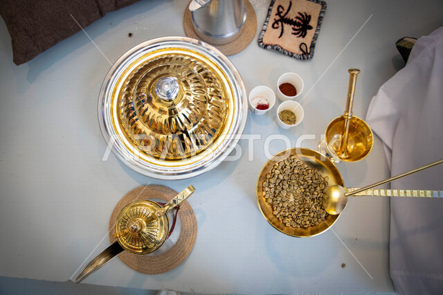 صورة مقربة لأدوات تحضير بذور البن الطازج، دلة قهوة، البهارات المستخدمة في اعداد القهوة، طبق من بذور القهوة الطازج، اعداد وتحضير القهوة الطازجة للمناسبات والاحتفالات والاعياد، صنع مشروبات الضيافة الساخنة من حبوب البن 